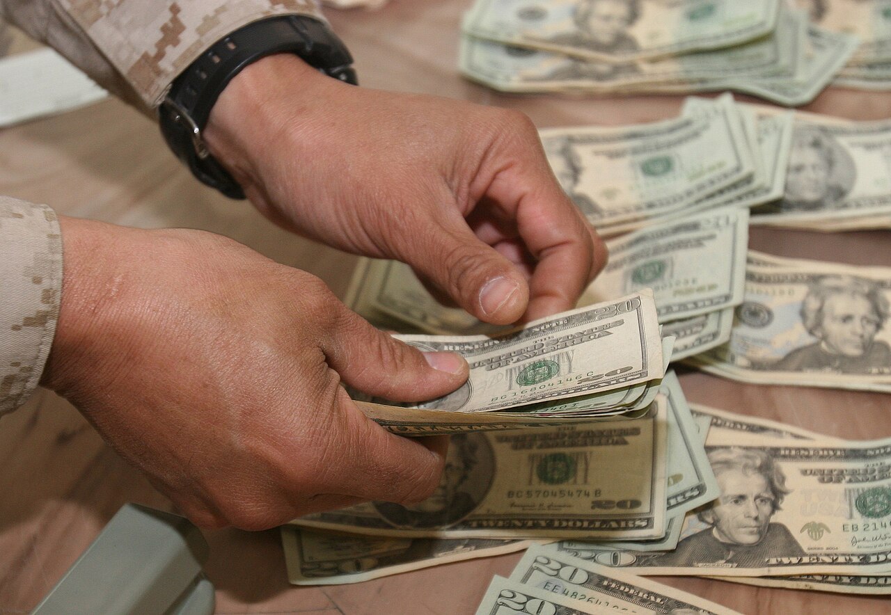 Person counting dollar bills received as a remittance